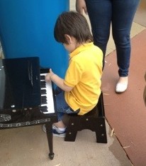 child playing a toy piano
