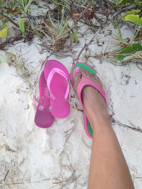 kid-sized pink flip-flops next to adult sized pink flip-flops