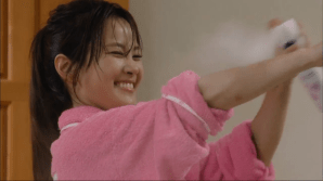 woman smiling while spraying on whitener