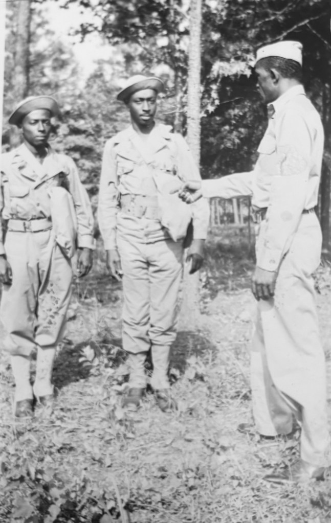 Cuthbert Prout standing with two troopsin WWII